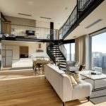 Yüksek tavanlı geniş pencereleri ve endüstriyel tasarımıyla öne çıkan loft daire konseptinde ferah salon.